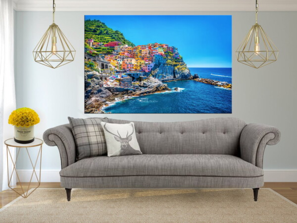 תמונת בתים צבעוניים בחצי האי האיטלקי עם שמיים וים כחולים, בסלון בהיר, מייצרת שילוב יפה של צבעים רכים וניגודיות בולטת.