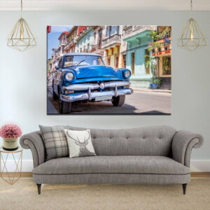 תמונה של מכונית קלאסית כחולה בקובה, תלויה בסלון בהיר, מביאה נופך נוסטלגי וייחודי עם עיצוב מודרני.
