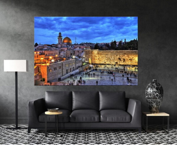 תמונה של הכותל בירושלים עם כיפת הזהב ושמיים כחולים ומעוננים, מוצגת בסלון כהה, יוצרת ניגודיות מרהיבה ותחושת דרמה.