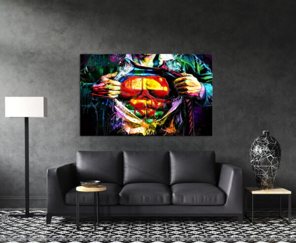 תמונה של סופרמן עם כתמים צבעוניים, תלויה בסלון כהה, יוצרת ניגודיות מרהיבה עם אפקט צבעוני בולט.