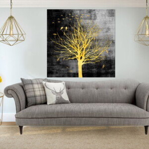 תמונה של עץ מוזהב על רקע שחור, בסלון בהיר, משדרת תחושת שלווה ועומק עם עיצוב יוקרתי.