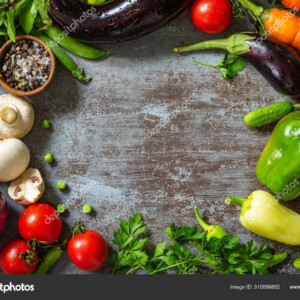 מגוון ירקות כמו פטריות, פלפלים, גזרים וחצילים. מונחים על שולחן בצבע אפור עם מבט מלמעלה.