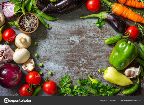 מגוון ירקות כמו פטריות, פלפלים, גזרים וחצילים. מונחים על שולחן בצבע אפור עם מבט מלמעלה.