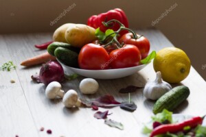 צלחת ירקות עם תפוחי אדמה, עגבניות ומלפפונים על משטח בהיר