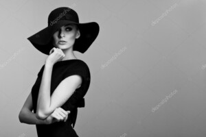 אישה בצילום מגובה מותן - עם שמלה שחורה וכובע רחב שוליים - תמונת שחור-לבן_33622661
