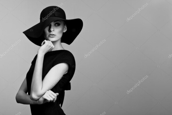 אישה בצילום מגובה מותן - עם שמלה שחורה וכובע רחב שוליים - תמונת שחור-לבן_33622661