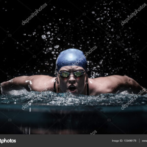 שחיינית שוחה פרפר בבריכה סגורה - 133496178