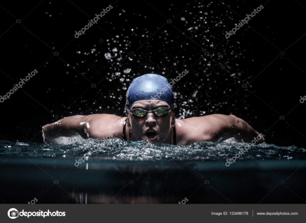 שחיינית שוחה פרפר בבריכה סגורה - 133496178