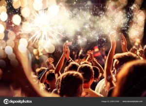 תמונה של חגיגה של אנשים מרימים ידיים עם זיקוקי דינור בהופעה_226473184