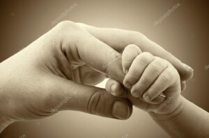 תמונת קונספט של תינוק - החיבור בין תינוק להורה - יד של תינוק מחזיקה אצבע ביד של מבוגר_19456397