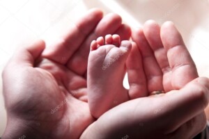 תמונת תינוק - איברי גוף - ידיים מבוגרות מציגות רגל של תינוק_45709701