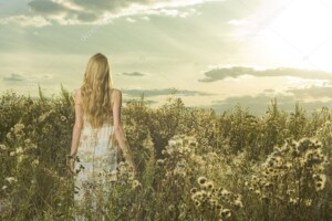 אישה בשדה פרחים צופה אל השמש - תמונת טבע ויופי - תמונת השעה המוזהבת - 4084122