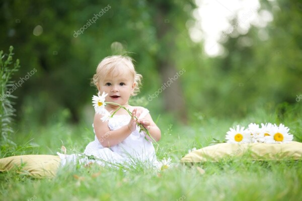 תינוק יושב על הדשא מחזיק פרח - תמונת ילדים טבע ונוף_9723576