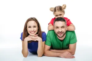 תמונה משפחתית של זוג וילדה בסטודיו על רקע לבן